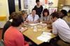 Group of people round a table, at work, talking